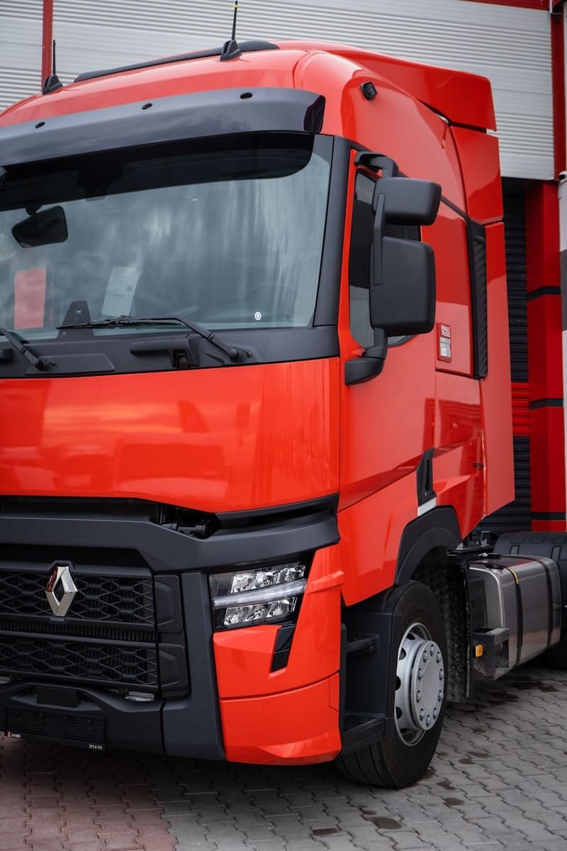 Photo by Ömer Haktan Bulut a red truck parked in front of a building