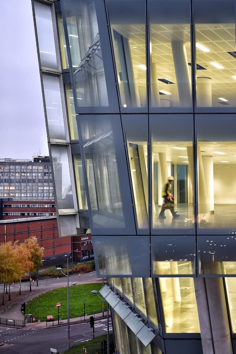Modern glass office building beside a city road, representing civil engineering recruitment for infrastructure projects