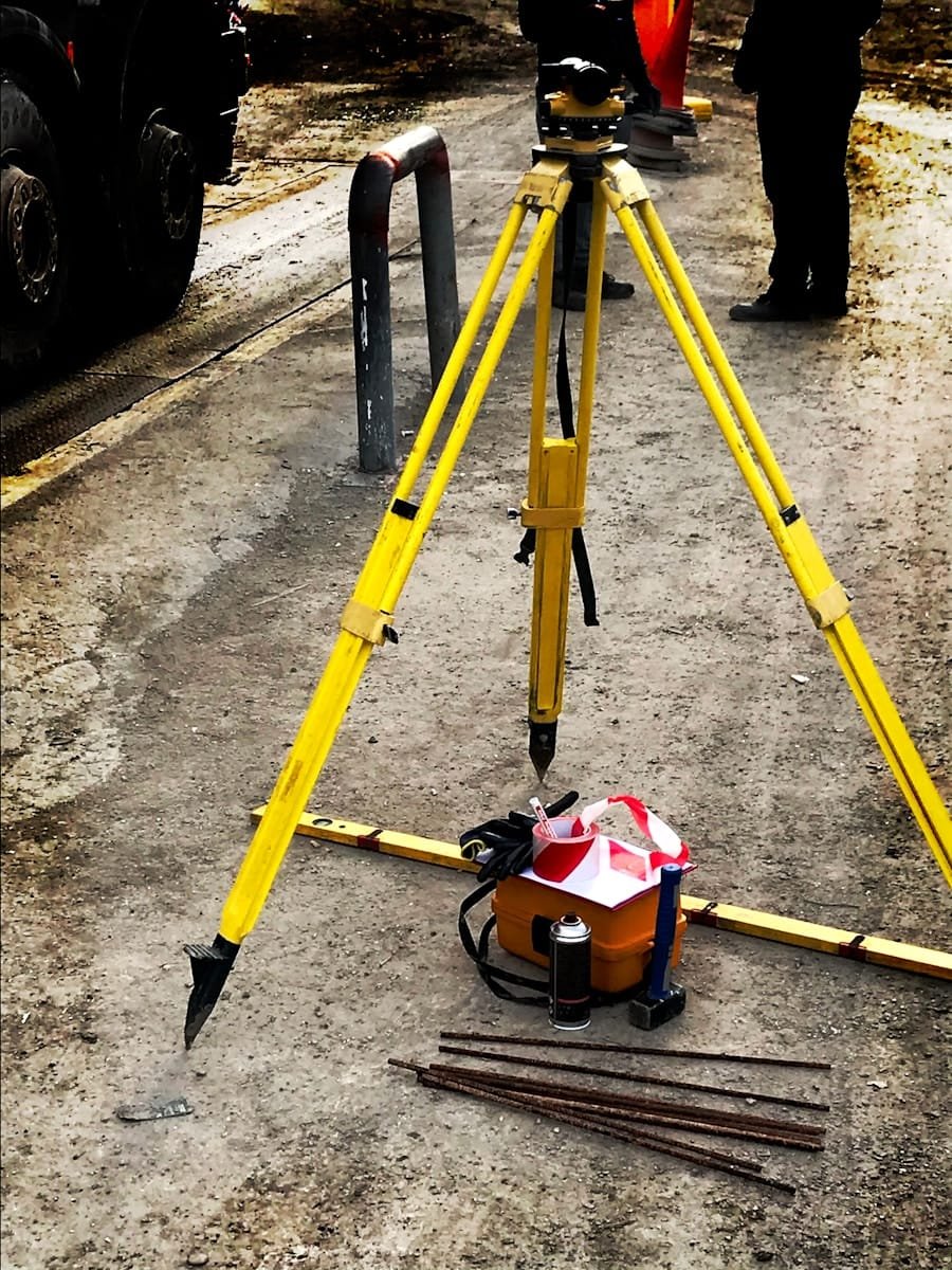 Photo by Elias Tsapaliaris {ilias_fly_zen} Surveying tripod and levelling equipment on a construction site, representing quantity surveyor recruitment